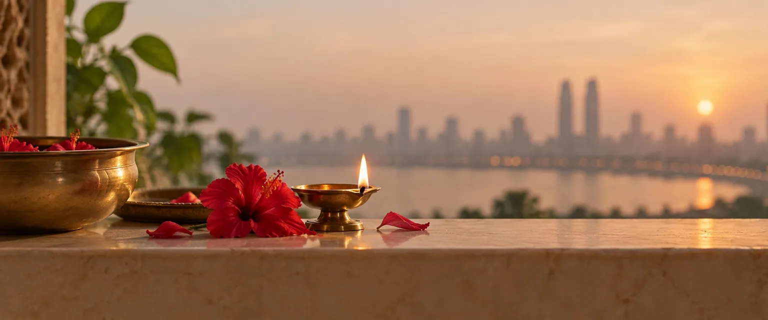 A lit diya and hibiscus before a blurred skyline of twin towers - Financial Astrologers in Malaysia